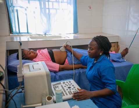 A health worker giving a pregnant woman an ultrasound scan